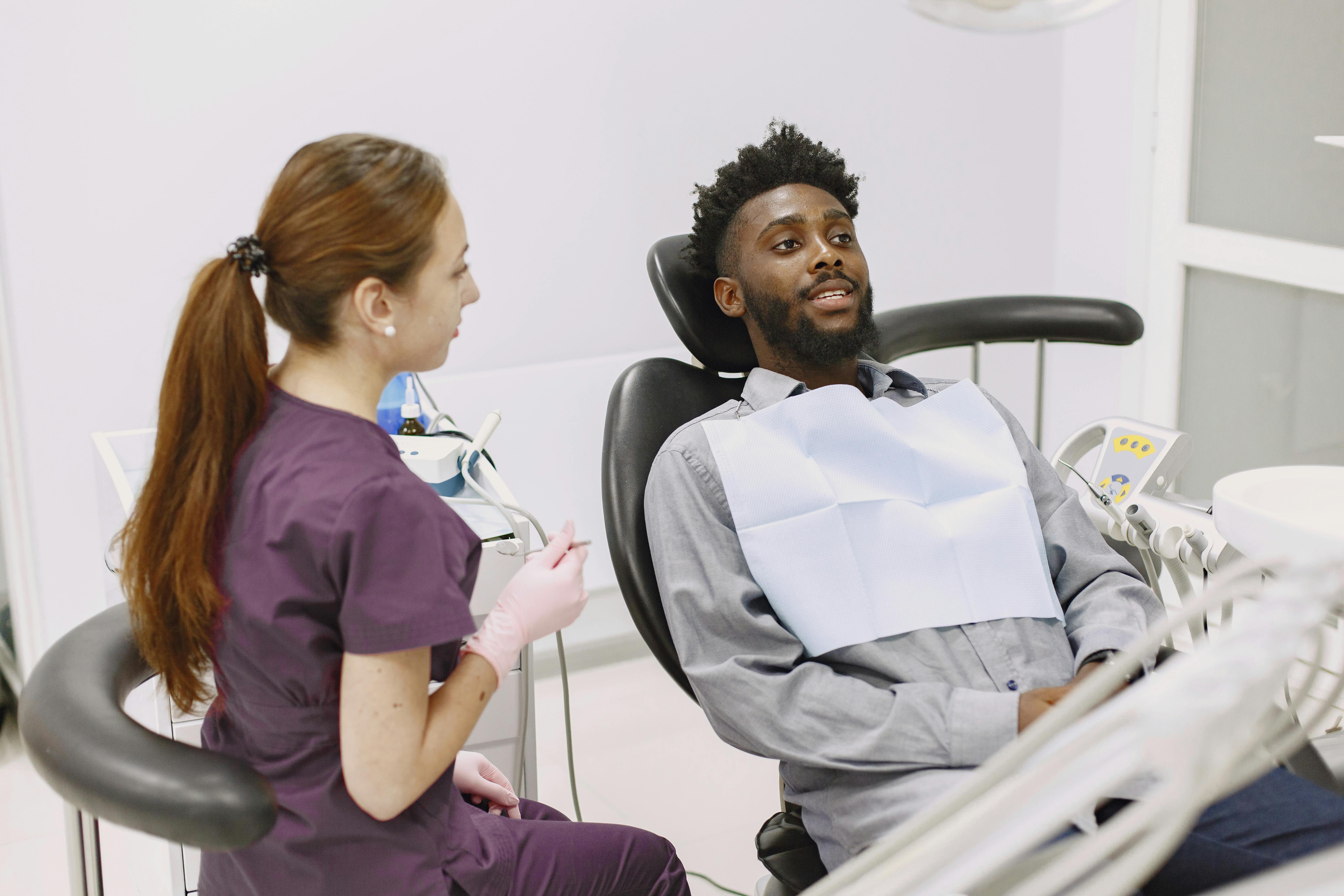 Patient talking with a dentist in a treatment chair before an appointment